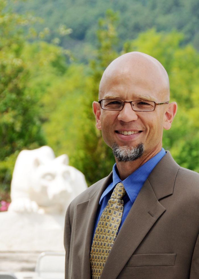 head shot of man in front of nittany lion shrine