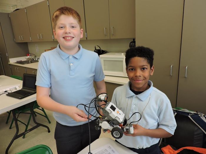 two students holding robotics