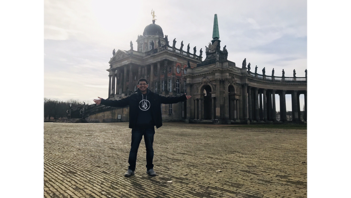 student in front of a German building