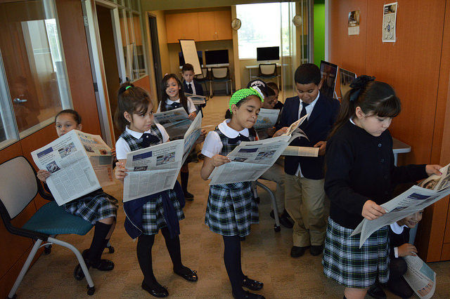 group of students reading newspapers
