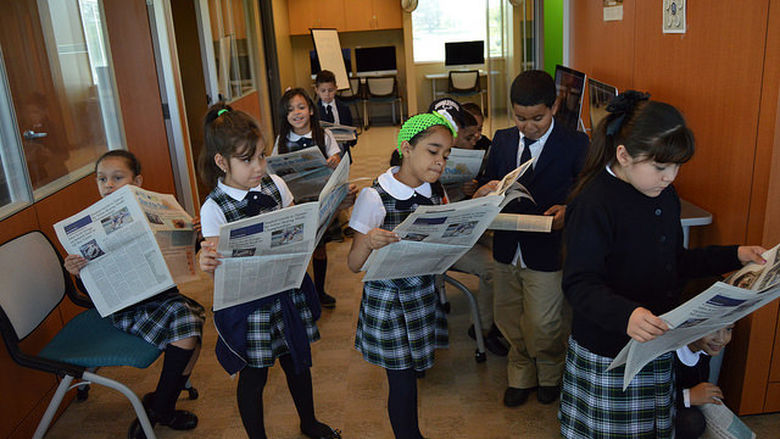 group of students reading newspapers