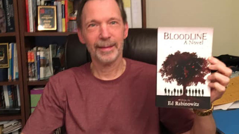 Ed Rabinowitz holds up a copy of his book, "Bloodline"