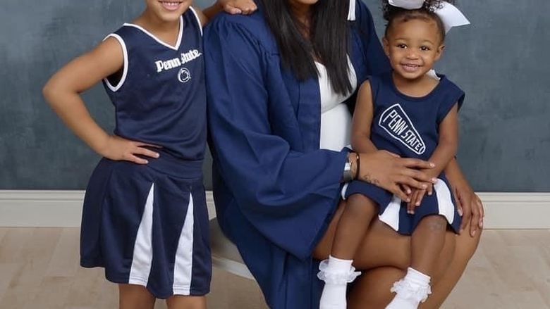 A women with her daughters dressed in Penn State cheerleading outfits