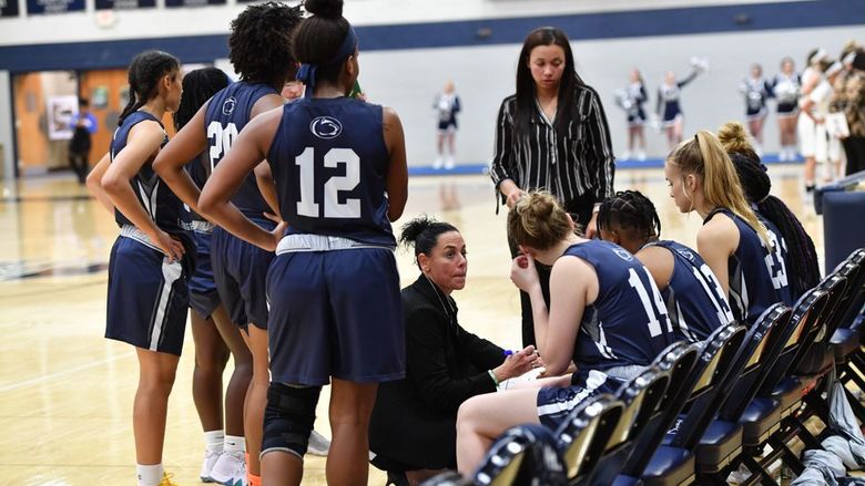 A group of women's basketball players in a huddle.