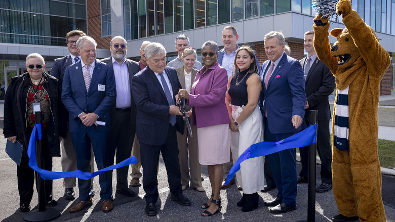 Penn State President Eric J. Barron and Penn State Lehigh Valley Chancellor Tina Q. Richardson cut a blue ribbon while standing in front of the new PSU-LV expansion.