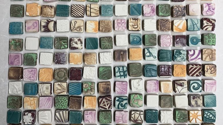 Small square tiles with multiple color glazes grouped in the shape of a square