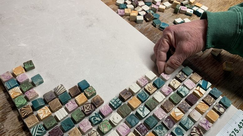 A person working on a mosaic tile project