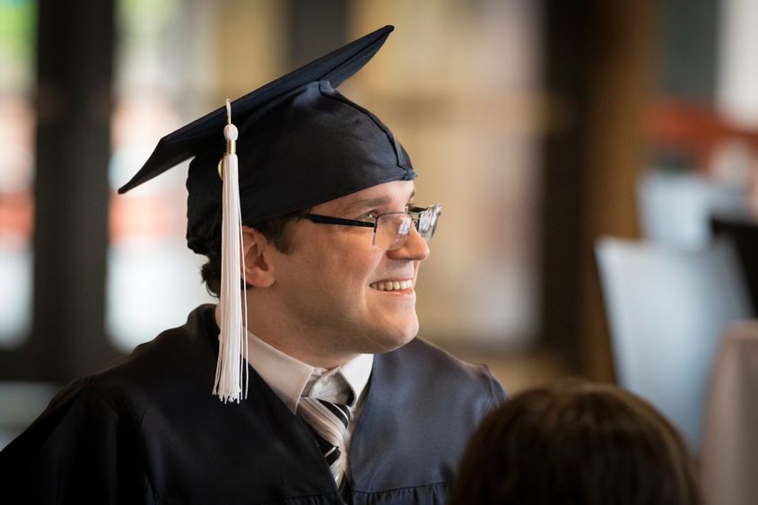 man with graduation cap on looking off into distance
