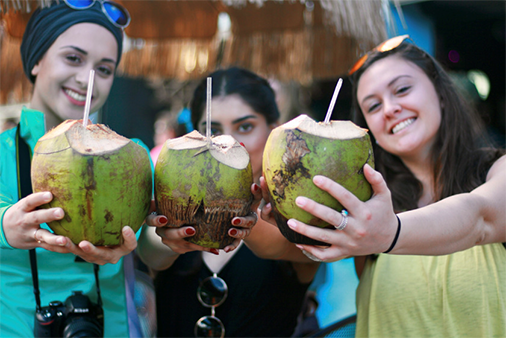 A group of students holding coconut drinks