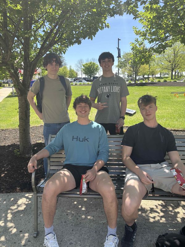 students smiling on bench 