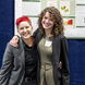 Two students pose in front of a poster about invasive species at the regional symposium