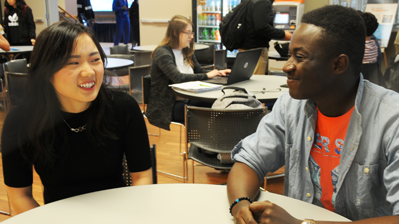 Two students sitting at a table in Lion's Den cafeteria