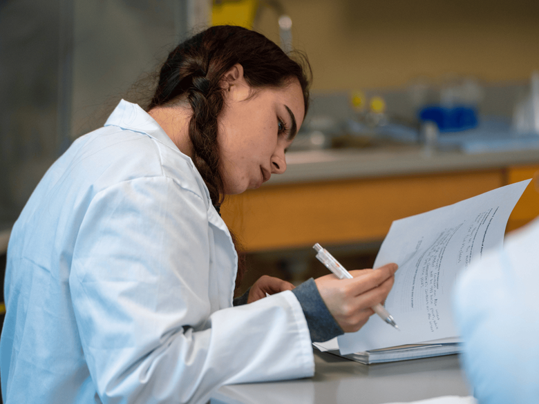 student studying in lab coat 
