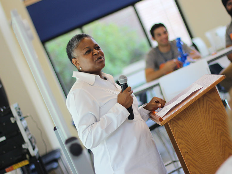 chancellor richardson speaking to an audience of faculty and staff with a microphone