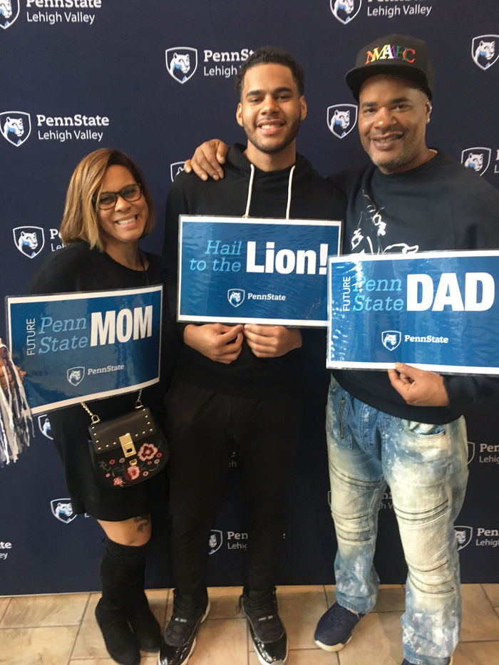 a son with his parents holding PSU signs