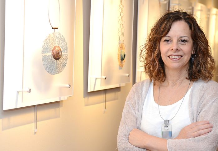 woman smiling in art gallery next to pieces of art