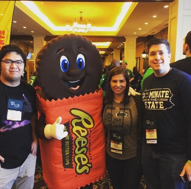 3 students posing with Reeses mascot 