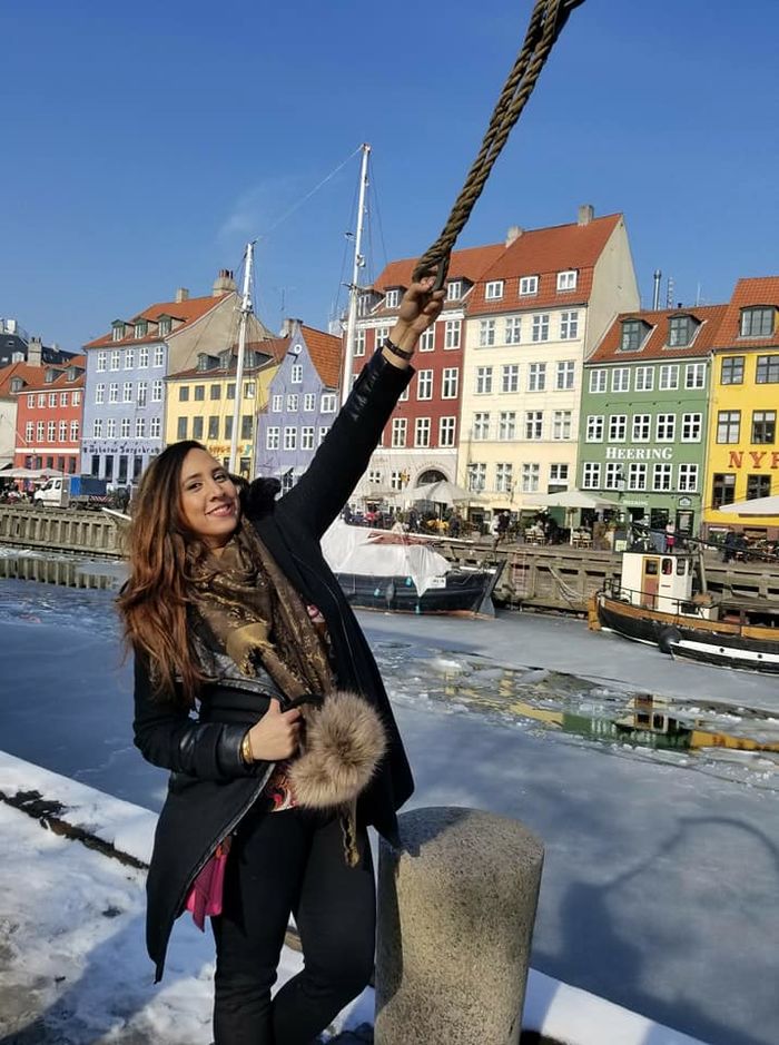 young woman posing in front of traditional buildings in Denmark