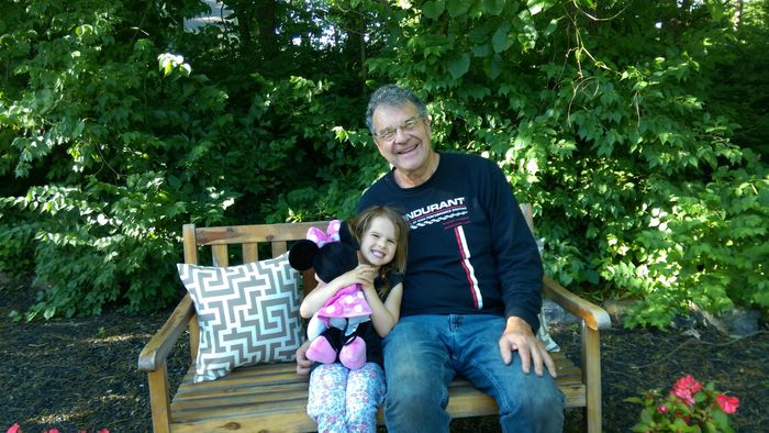 man sitting on bench with granddaughter
