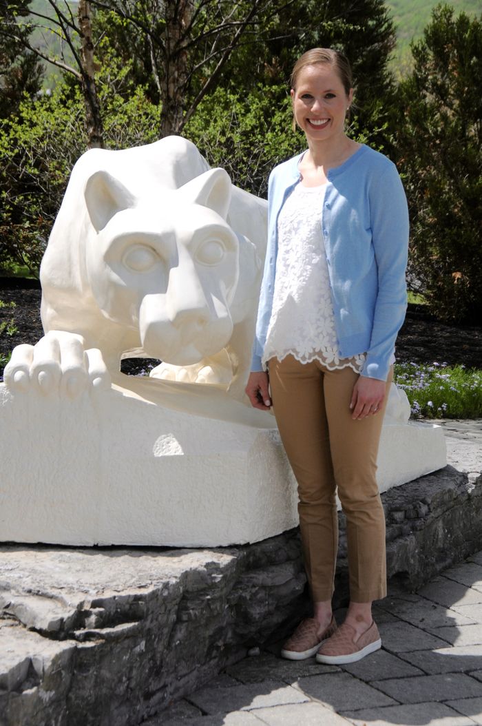 Woman standing in front of lion shrine