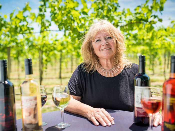 Woman sitting at table in vineyard