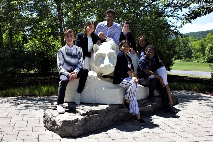 group of students posed around Nittany Lion shrine