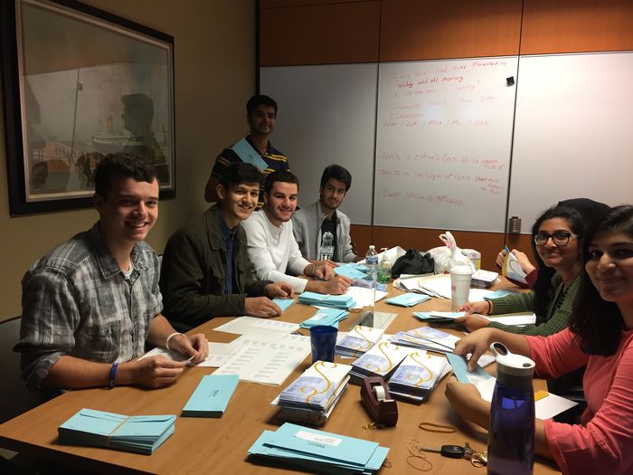 students around a table stuffing envelopes
