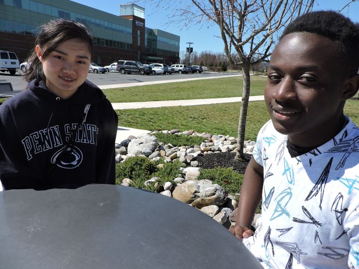 Two students sitting at a table outside of campus