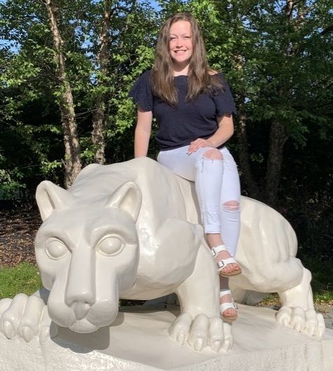 Student sitting on Penn State nittany lion statue