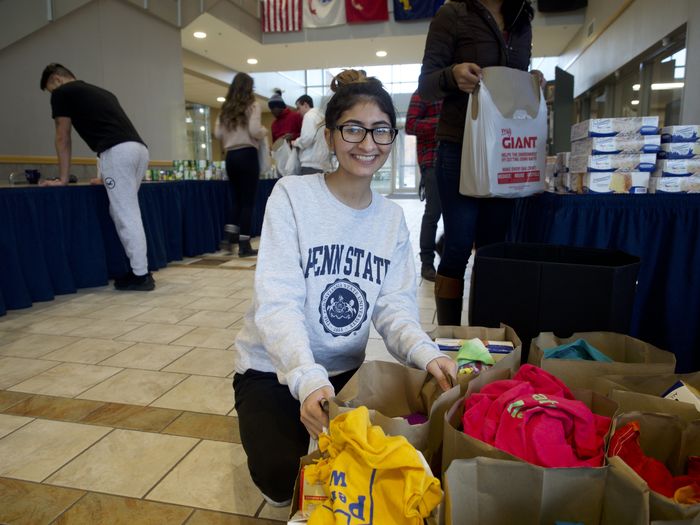 Student organizing bags of donated items