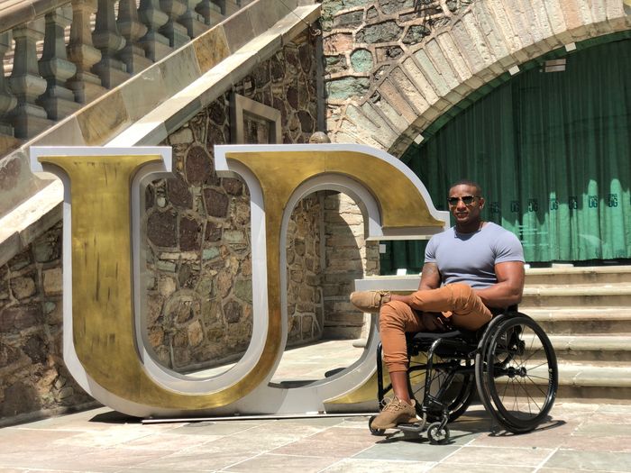 man in wheelchair near logo statue in Mexico