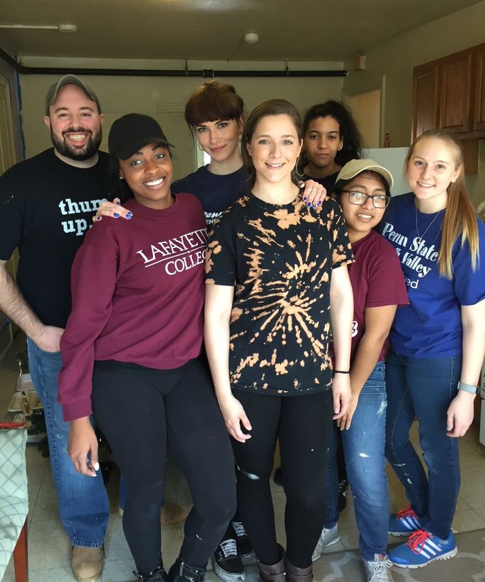 Group of students and staff member posing while volunteering