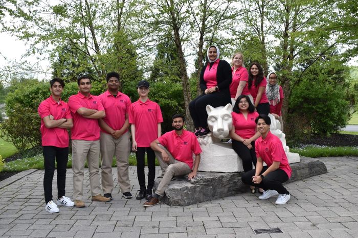 group of students standing by lion shrine 