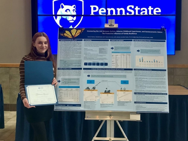 Gianna Gomes standing in front of her research poster