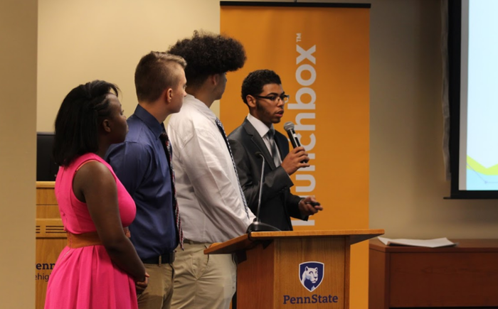 Group of students presenting with microphone and podium