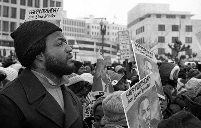 Man with tear running down his face in a crowd at a Dr. Martin Luther King celebration.