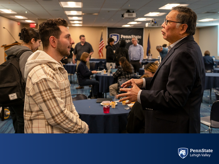 a professor and local businessman engage in conversation
