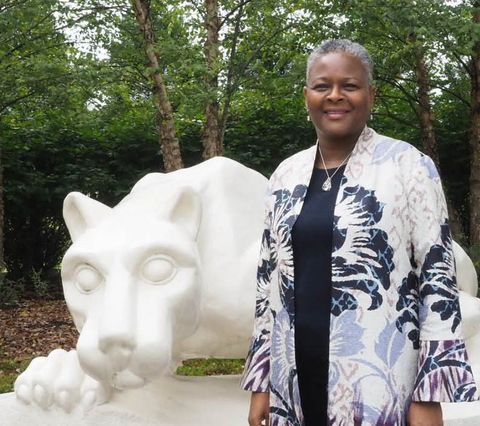 Dr. Richardson photo - Woman smiling, standing next to lion shrine