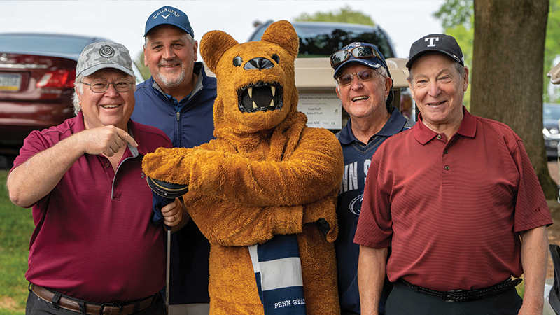 Four male golfers pose with the Nittany Lion mascot.