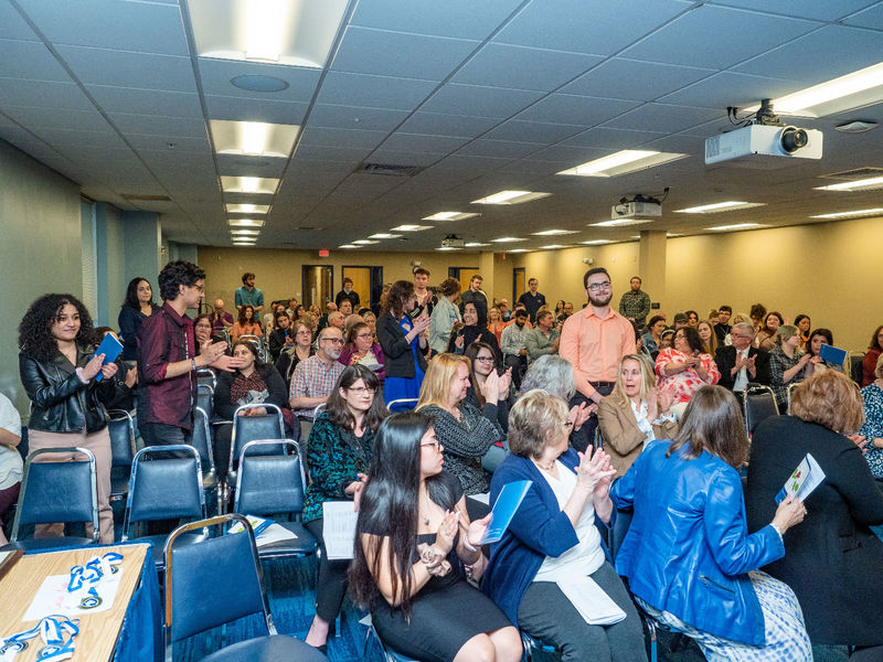 Student receives applause from crowd at awards ceremony 