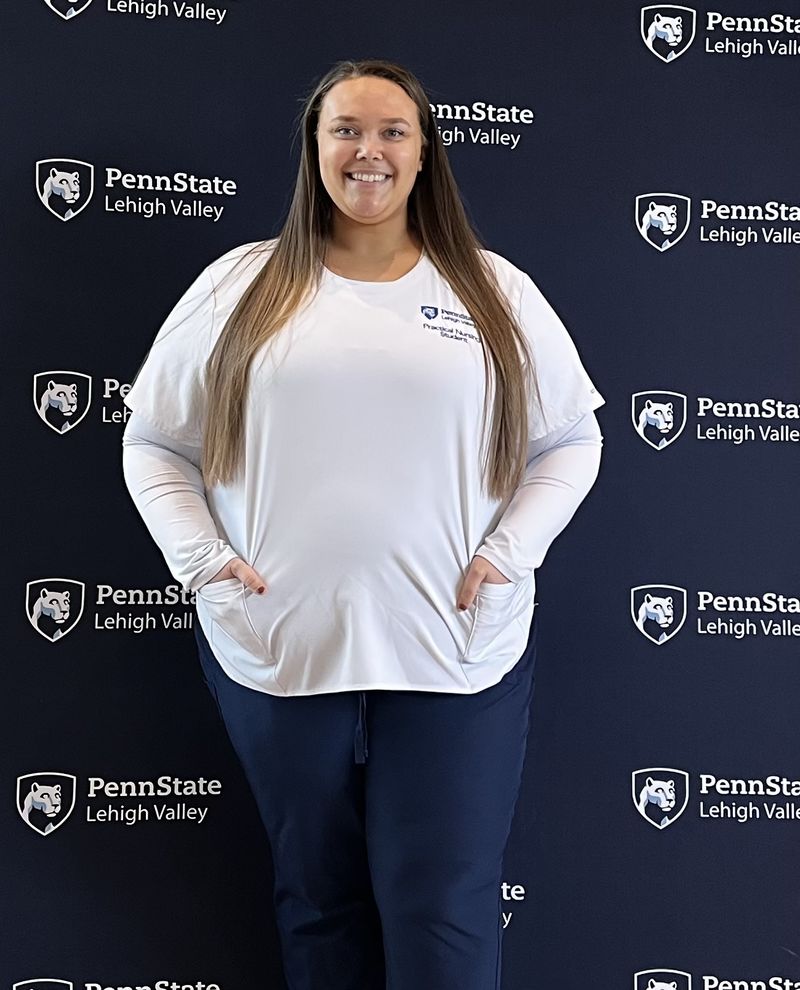 woman in nursing outfit smiling at camera 