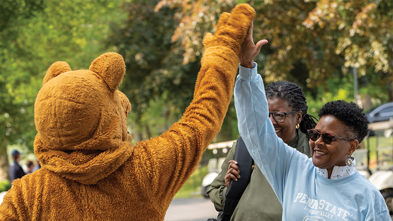 Dr. Richardson giving the Nittany Lion mascot a high five.