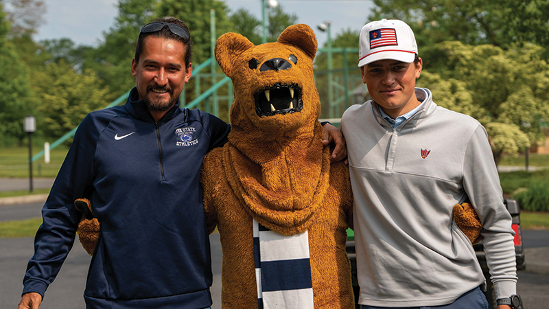 two male golfers stand with the Nittany Lion mascot