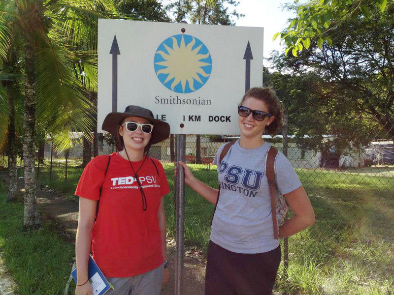 Two Penn Staters pose near a sign pointing to the Smithsonian Tropical Research Institute in Panama.