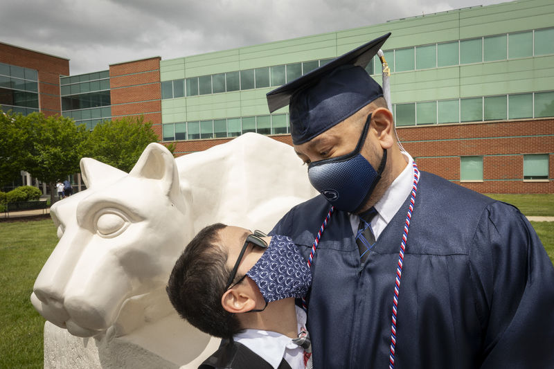 boy looking up at man in cap and gown