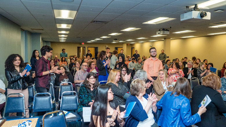 Student receives applause from crowd at awards ceremony 