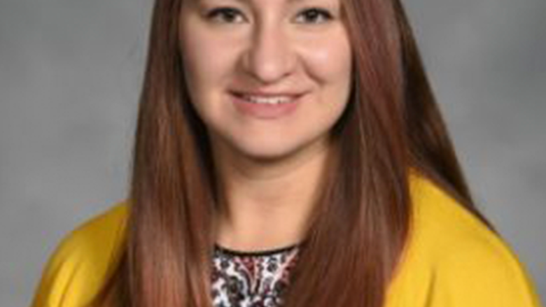 Woman smiling, looking at camera.