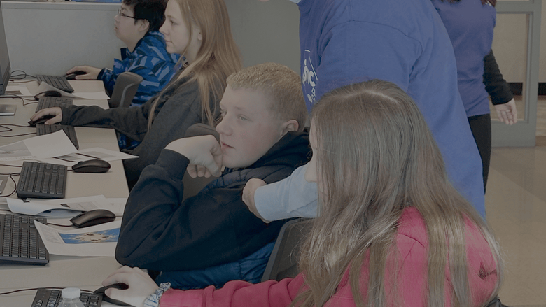 Man showing boy and girl something on computer 