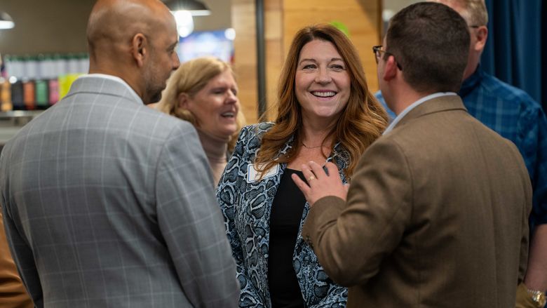 woman laughing talking to two men 