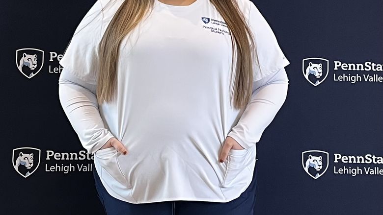 woman in nursing outfit smiling at camera 